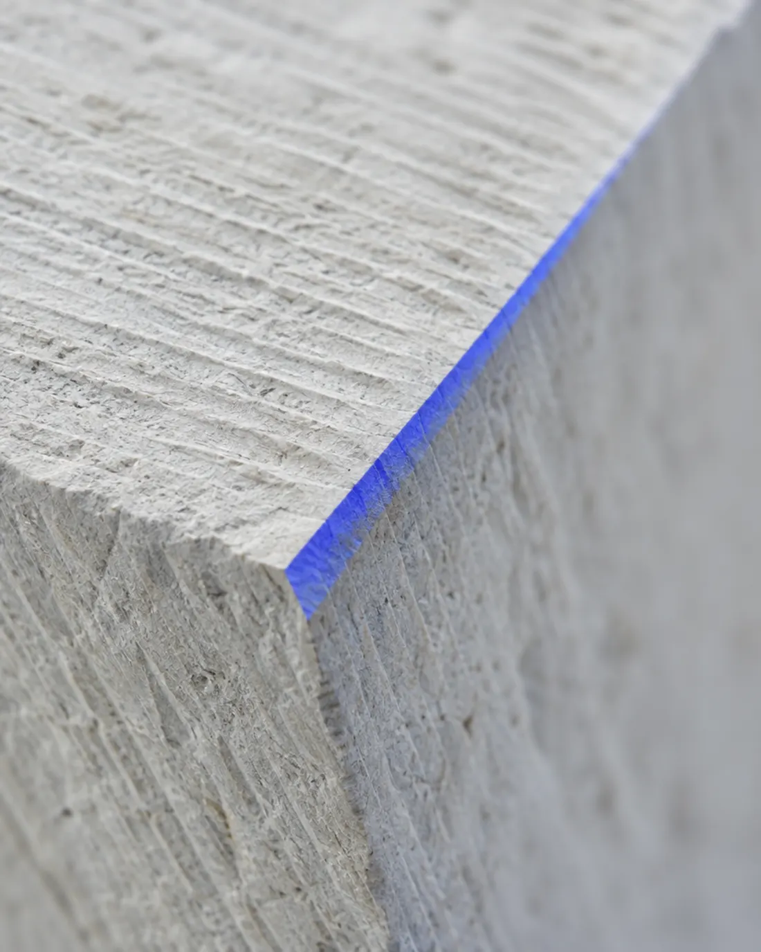 Carved stone edge catching a thin line of blue light
